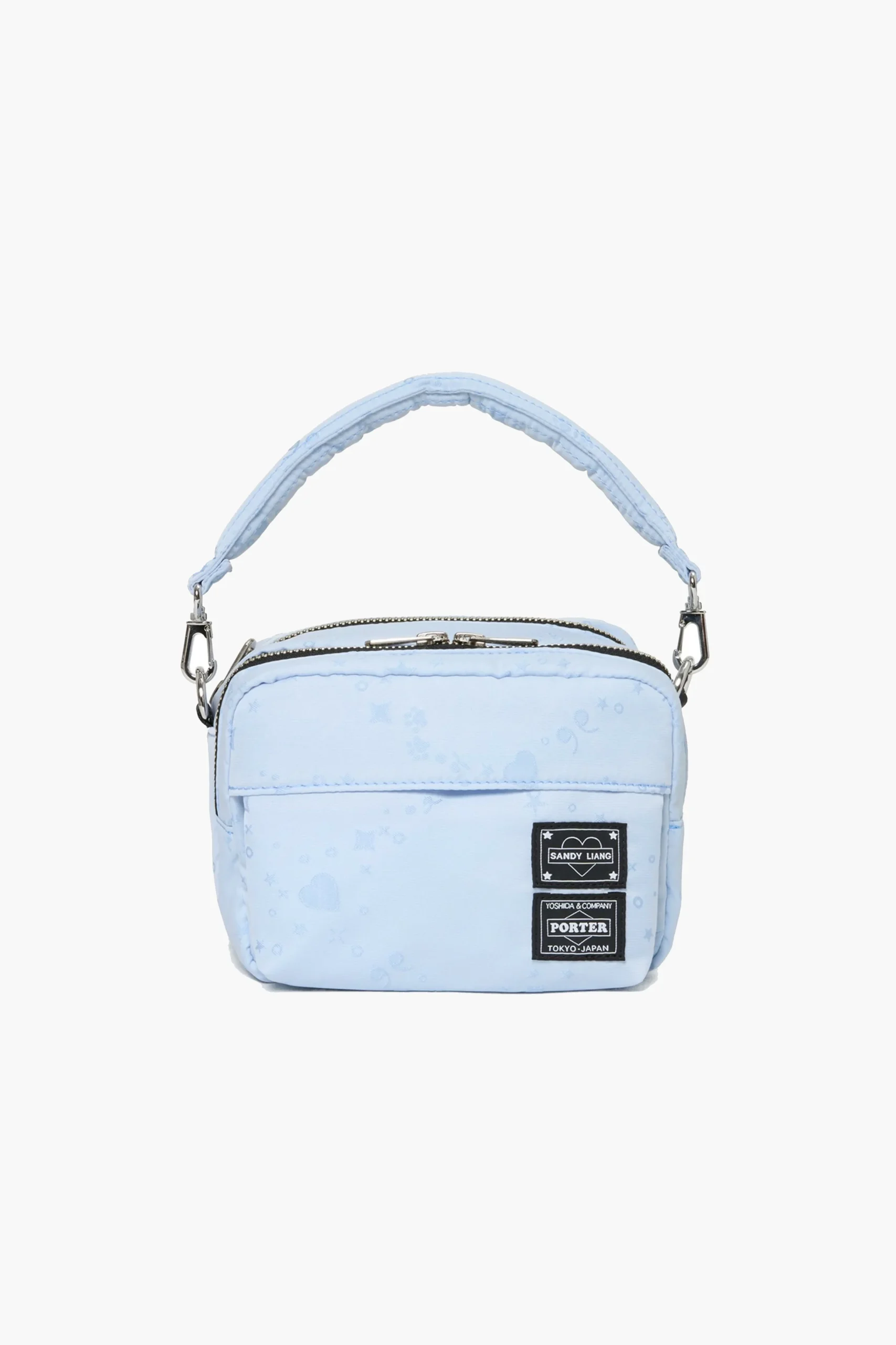 Light blue Andy Liang x Porter Muffin Bag in padded nylon with subtle star and heart motifs, featuring a short top handle, silver hardware, and co-branded Sandy Liang and Porter patches on the front