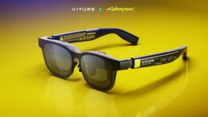 Black VITURE XR smart glasses displayed against a vivid yellow gradient background, featuring Cyberpunk 2077 collab branding with sleek rectangular lenses and detailed temple graphics
