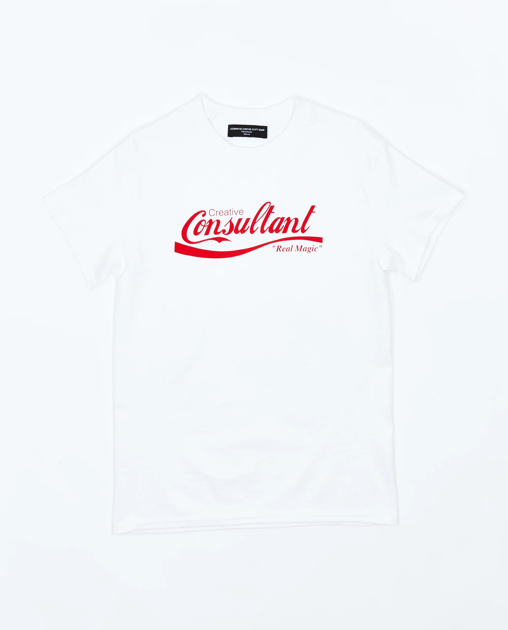 White T-shirt featuring a red script “Creative Consultant” logo with “Real Magic” tagline, designed in a corporate-style parody aesthetic reflecting Connie Costas bootleg culture streetwear