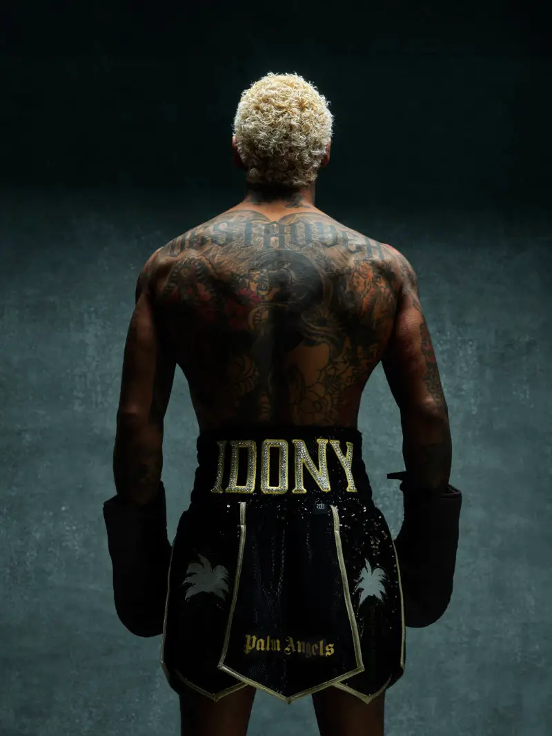 Back view of boxer wearing black Everlast × Palm Angels fight night trunks with gold “BENNY” lettering and palm tree graphics, paired with boxing gloves in a studio setting