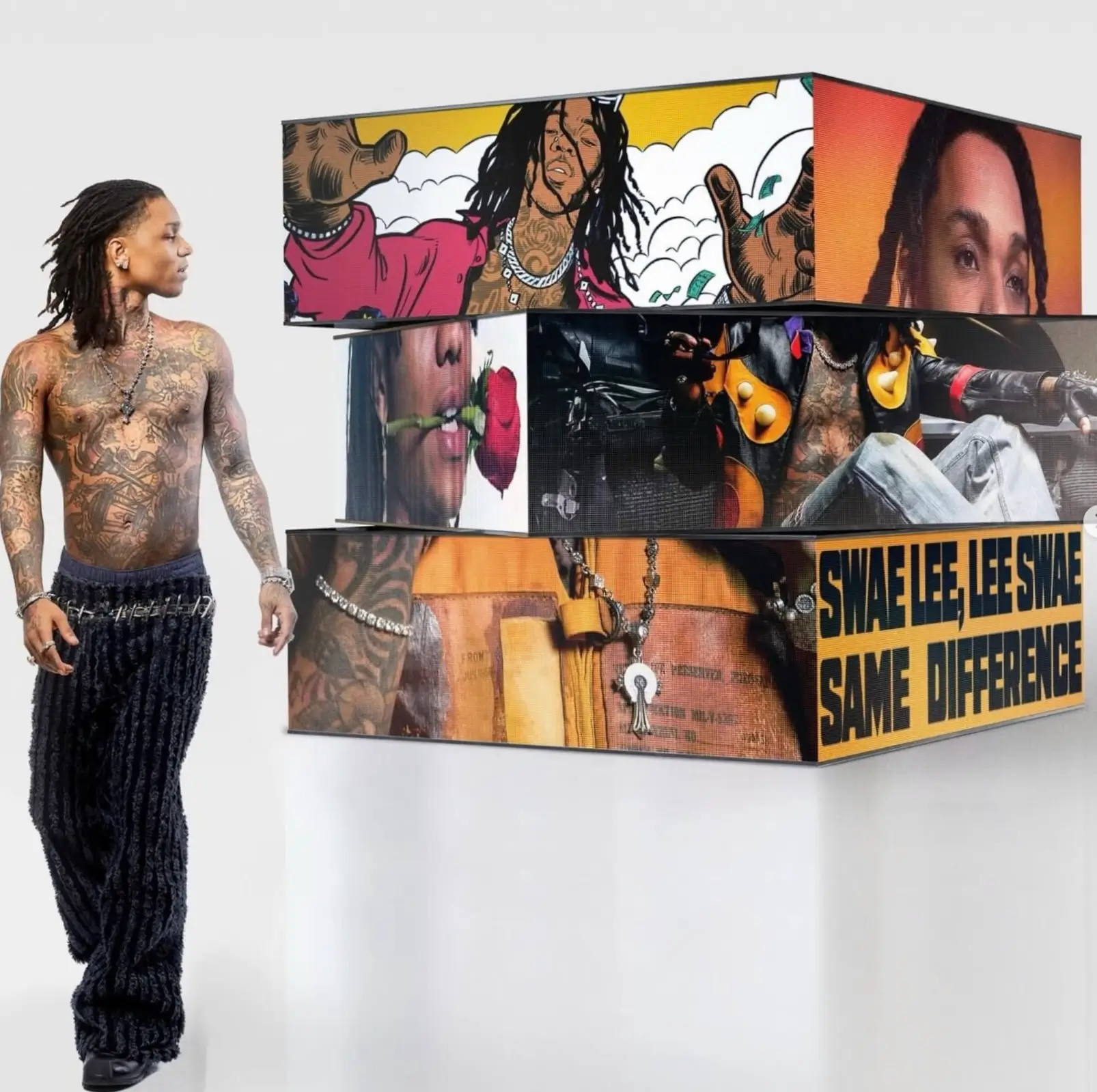 Swae Lee standing beside a stacked cube installation displaying stylized visuals from SAME DIFFERENCE, including illustrated portraits, close-up imagery, and bold yellow typography with the album title