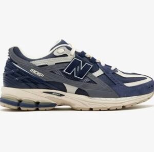 New Balance 1906U shoe in navy and grey with cream midsole, featuring mesh upper, layered synthetic overlays, ABZORB cushioning pods, and lace-up construction