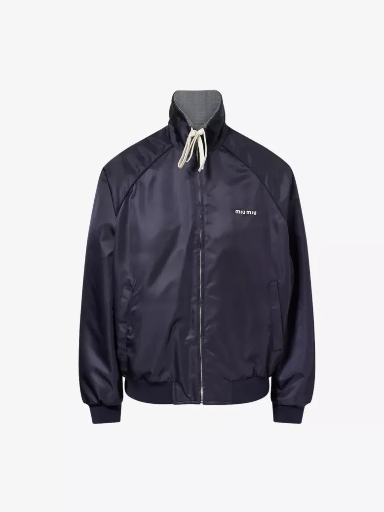 Navy Miu Miu blouson-style windbreaker with a zip front, ribbed cuffs and hem, stand collar with drawstrings, and a smooth technical finish against a neutral background
